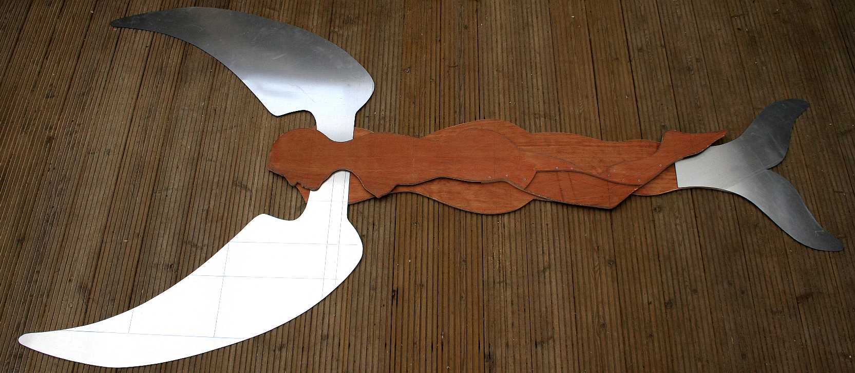 The aluminium wings and tail are cut from sheet metal to complete the set. Now begins the job of joining them all together. Plywood is made by bonding thin layers of wood together with the grain alternating in direction with each layer. By this means a flat board can be made that is very strong. Copyright © photograph.